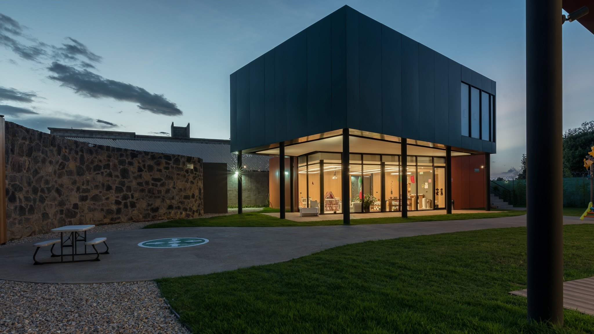 El colegio al anochecer, con los interiores iluminados
