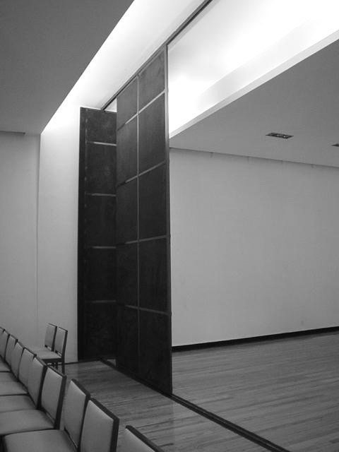 Corredor con muro oscuro a doble altura
