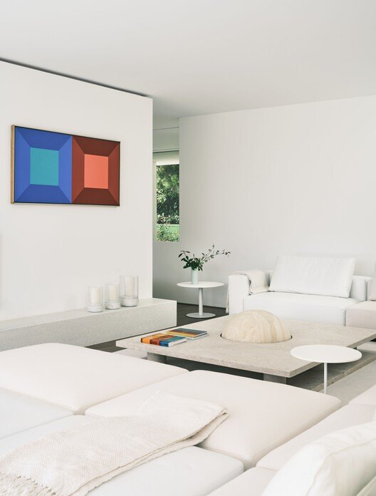 Sala blanca con una obra de arte geométrica