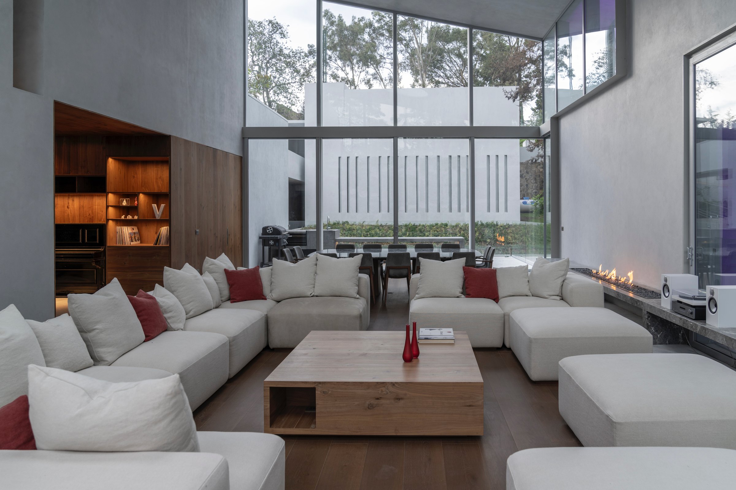 Sala de doble altura con ventanales al arbolado