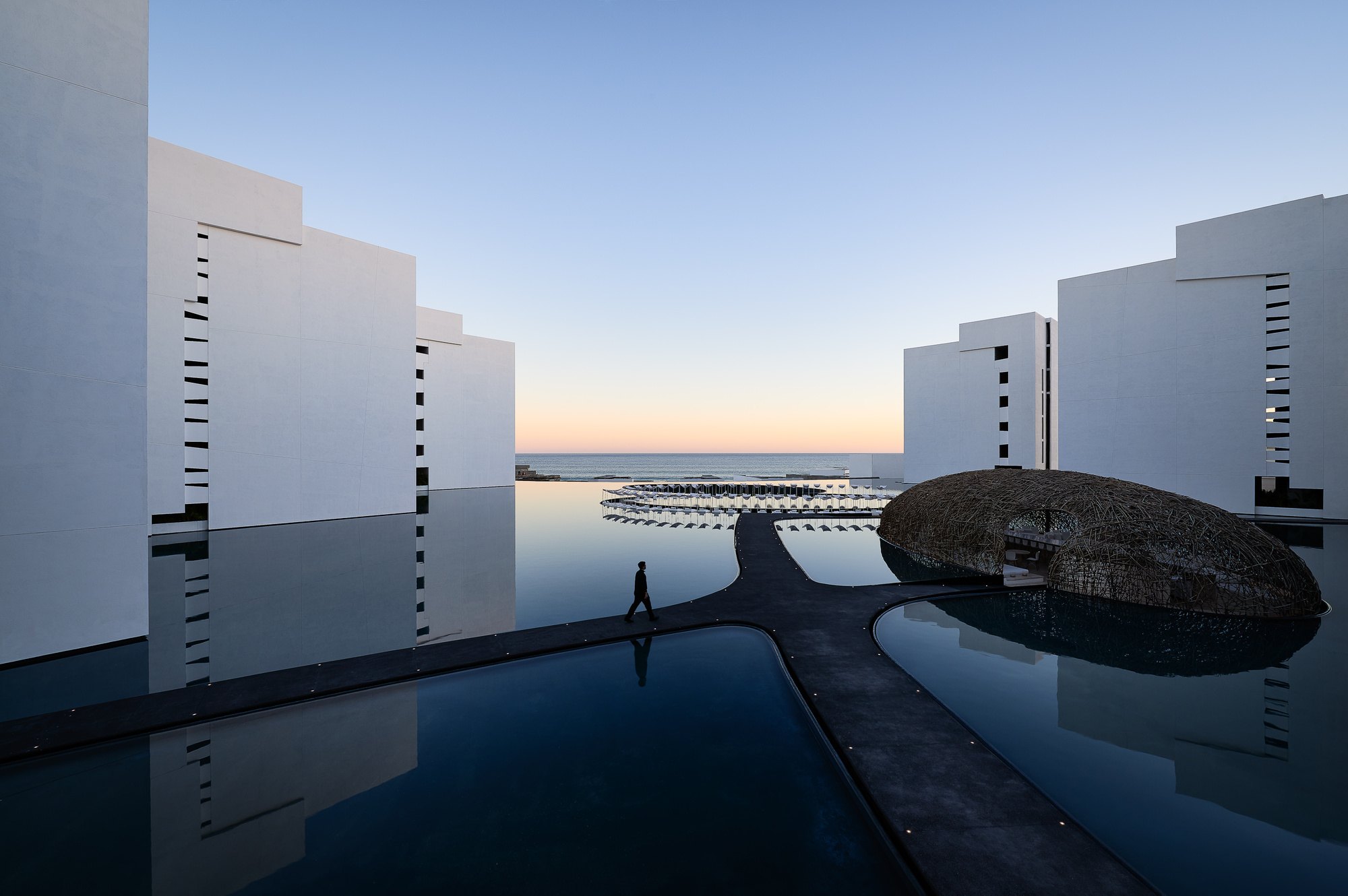 Volúmenes blancos sobre el espejo de agua al atardecer