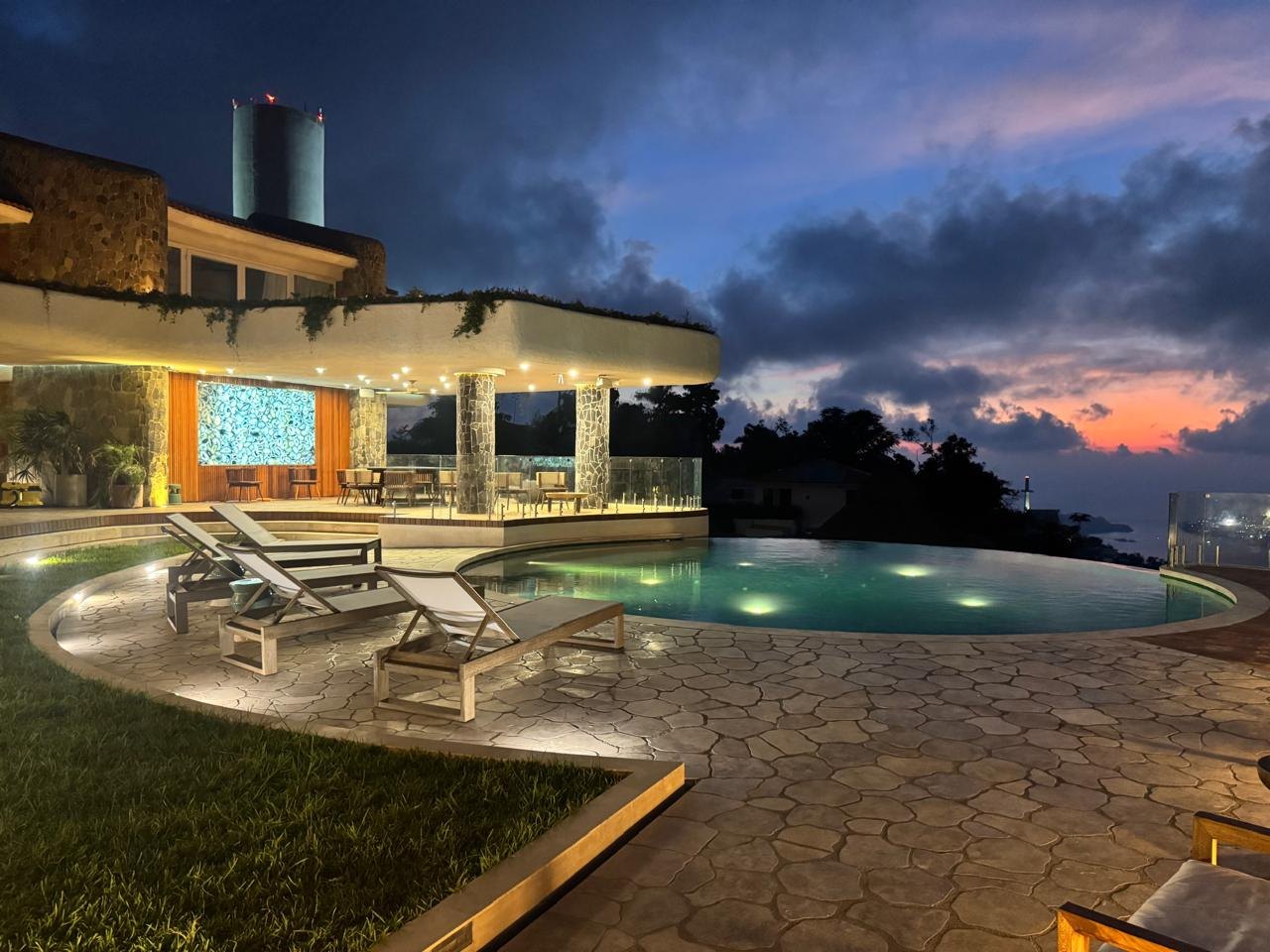 La alberca y la terraza sobre la bahía al atardecer